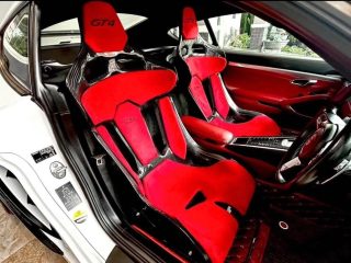KevMannz CF seats GT-Max with plug&play rails and slider kit for Porsche 718 Cayman (GT4 style), red Alcantara padding with GT4 logo stitching on headrest.